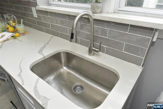 228 Ridgefield Ave, Bogota, NJ 07603 - kitchen view of a sink, backsplash, and light stone countertops