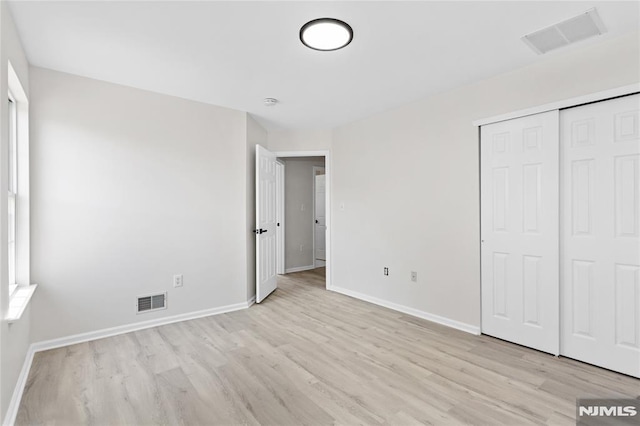 52 Straton Ct Unit 1006, Sayreville, NJ 08859 - unfurnished bedroom with light wood-style floors, baseboards, and a closet