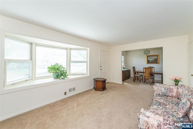 living area with light colored carpet and baseboards