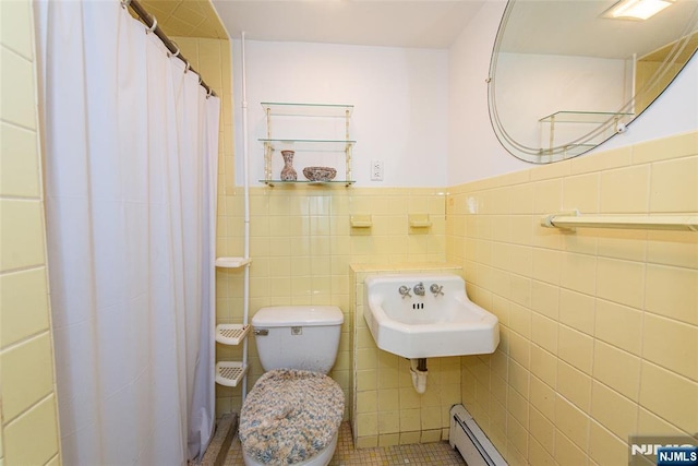 full bath featuring tile walls, a sink, a wainscoted wall, a shower with curtain, and toilet