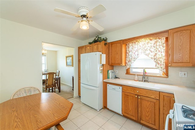 kitchen with white appliances, a sink, light countertops, decorative backsplash, and ceiling fan