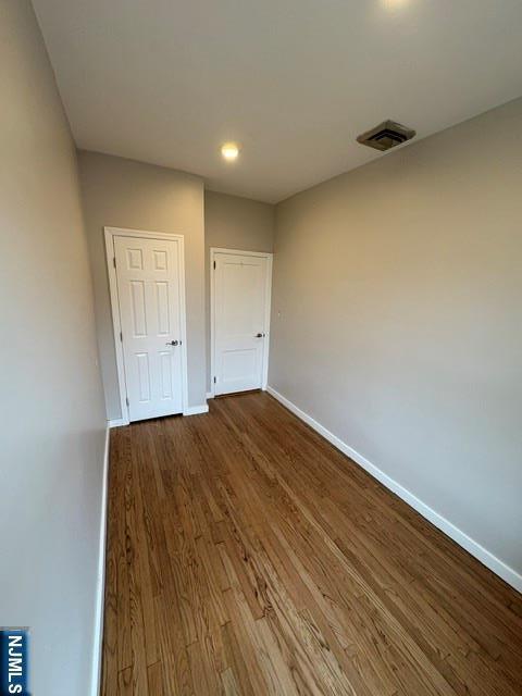 150 W 29th, Bayonne, NJ 07002 - unfurnished bedroom featuring wood finished floors, baseboards, and a closet