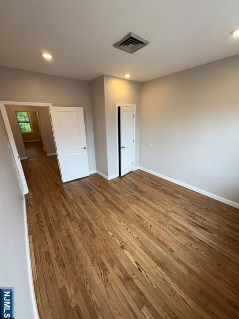 150 W 29th, Bayonne, NJ 07002 - unfurnished bedroom with dark wood finished floors, baseboards, and recessed lighting