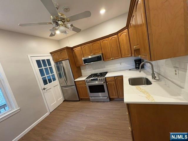 150 W 29th, Bayonne, NJ 07002 - kitchen featuring stainless steel appliances, a sink, backsplash, and a ceiling fan
