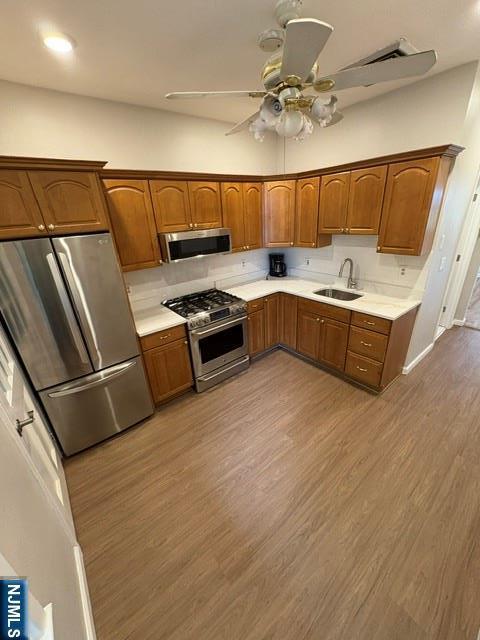 150 W 29th, Bayonne, NJ 07002 - kitchen featuring appliances with stainless steel finishes, a sink, wood finished floors, a ceiling fan, and light countertops