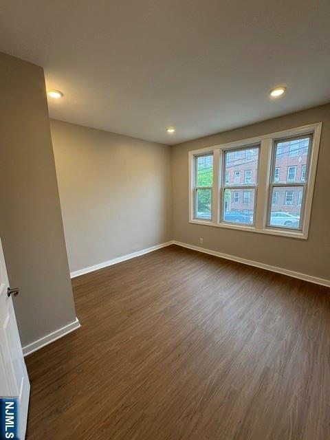 150 W 29th, Bayonne, NJ 07002 - spare room featuring dark wood-style floors, baseboards, and recessed lighting