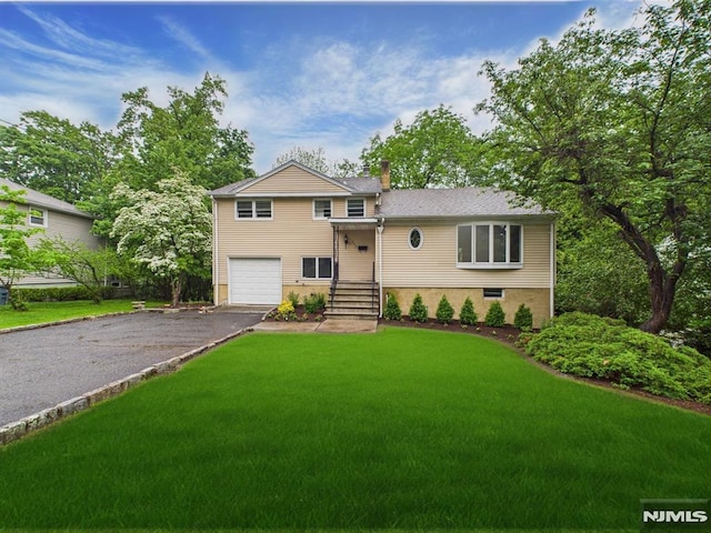 995 Andover Ter, Ridgewood, NJ 07450 - split level home with asphalt driveway, an attached garage, a front lawn, and a chimney