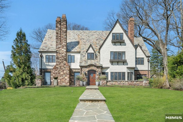 202 Crest Rd, Ridgewood, NJ 07450 - tudor-style house with a chimney, stucco siding, stone siding, and a front yard