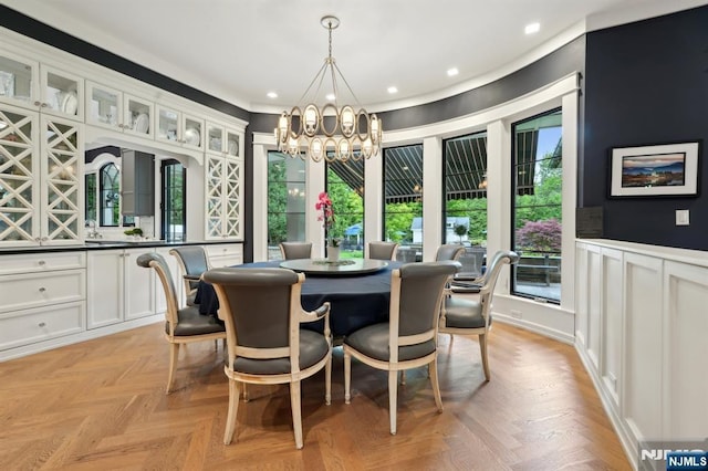 dining area with a chandelier, wainscoting, recessed lighting, a decorative wall, and ornamental molding
