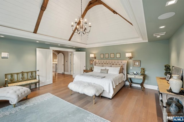 bedroom featuring a chandelier, arched walkways, wood finished floors, vaulted ceiling, and baseboards