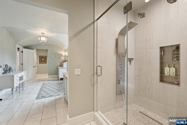 full bath with a shower stall, vanity, lofted ceiling, and baseboards