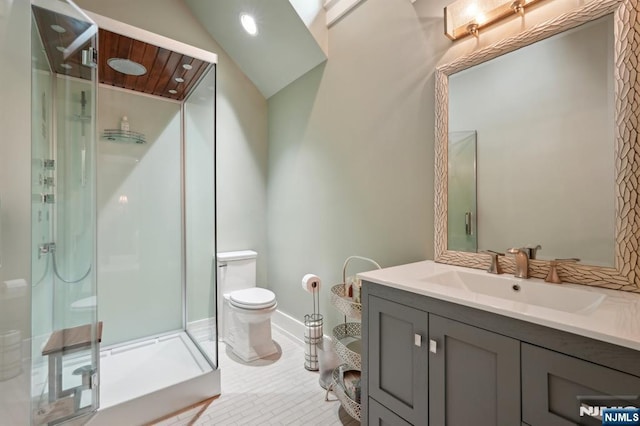 bathroom with toilet, a shower stall, vanity, baseboards, and tile patterned flooring