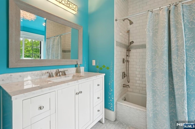 bathroom featuring tiled shower / bath and vanity