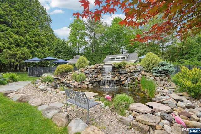 view of yard with a small pond and fence