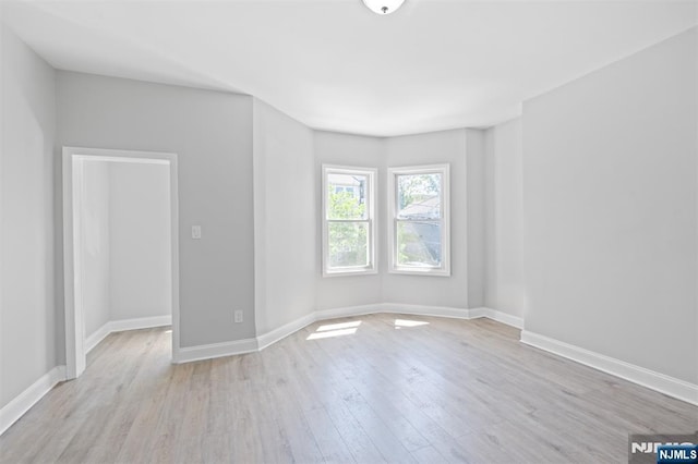 spare room featuring wood finished floors and baseboards