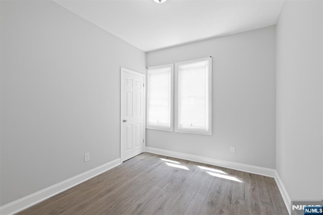 unfurnished room with baseboards and wood finished floors