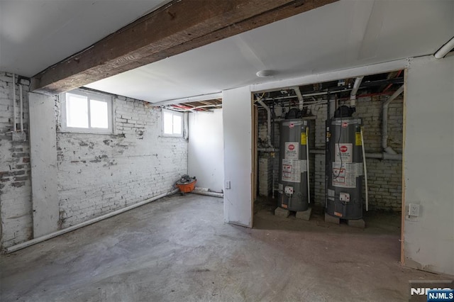 basement featuring gas water heater and brick wall