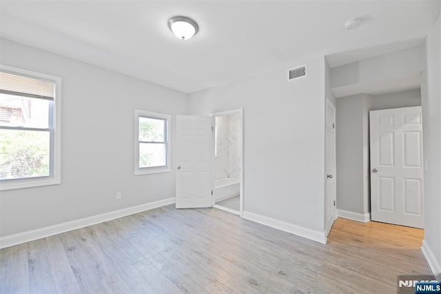 unfurnished bedroom with light wood-style flooring and baseboards