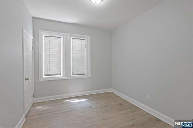 empty room featuring light wood-style floors and baseboards