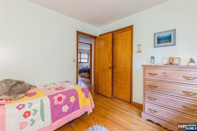 bedroom with light wood-type flooring and a closet