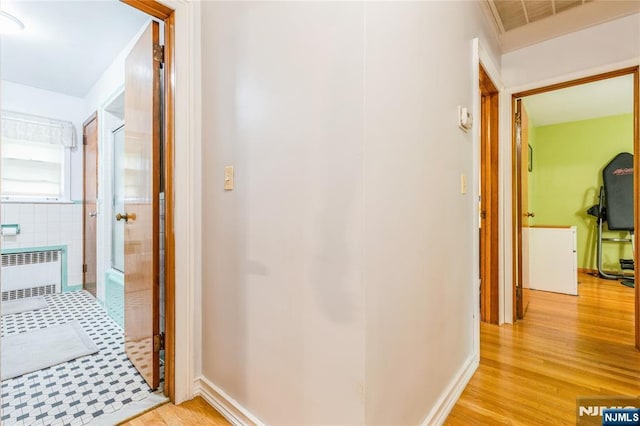 hall with radiator heating unit and light wood-style flooring