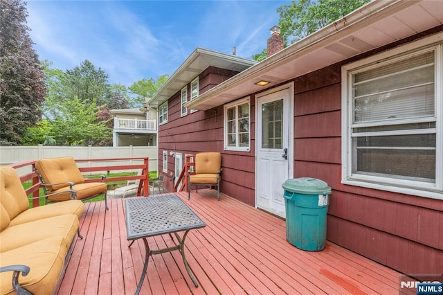 deck featuring an outdoor living space and fence