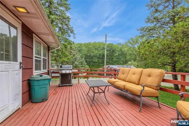 wooden terrace featuring grilling area and an outdoor living space