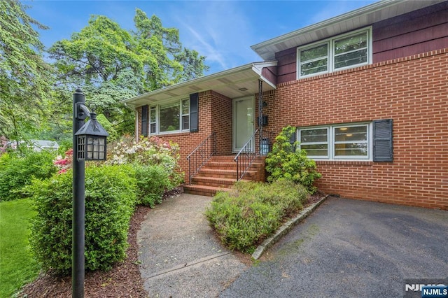doorway to property featuring brick siding