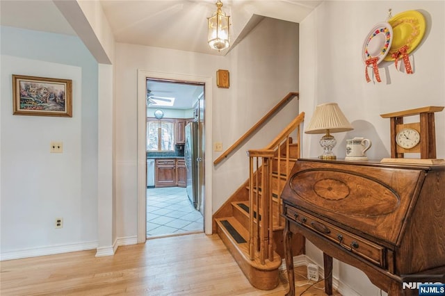 stairs with wood finished floors and baseboards