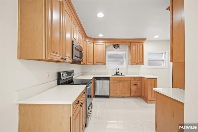 kitchen featuring stainless steel appliances, a sink, light marble finish flooring, recessed lighting, and light countertops