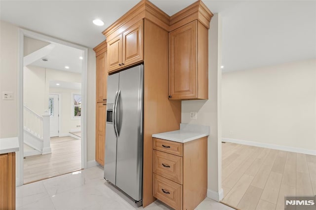 kitchen with stainless steel fridge with ice dispenser, light countertops, recessed lighting, and baseboards