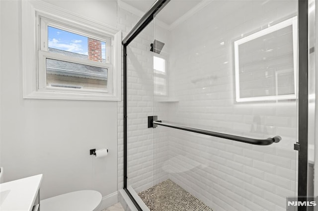 bathroom with toilet, a shower stall, vanity, ornamental molding, and baseboards