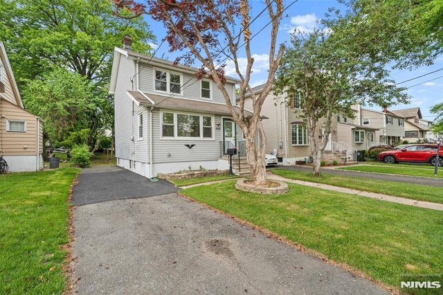 view of front of home with a chimney and a front lawn