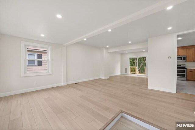 unfurnished living room featuring light wood-style floors, baseboards, and recessed lighting