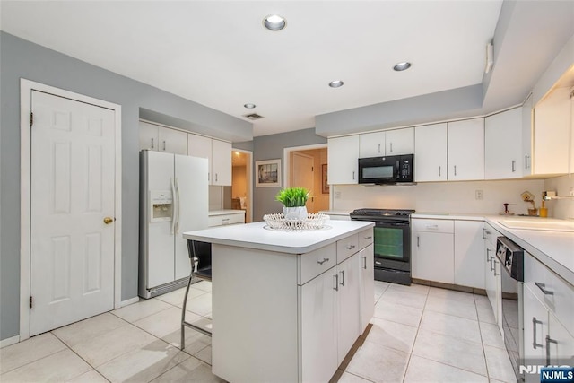 kitchen featuring black appliances, a sink, a center island, light countertops, and white cabinets