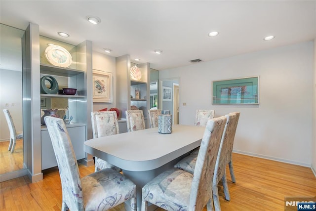 dining room featuring light wood-style floors, baseboards, and recessed lighting