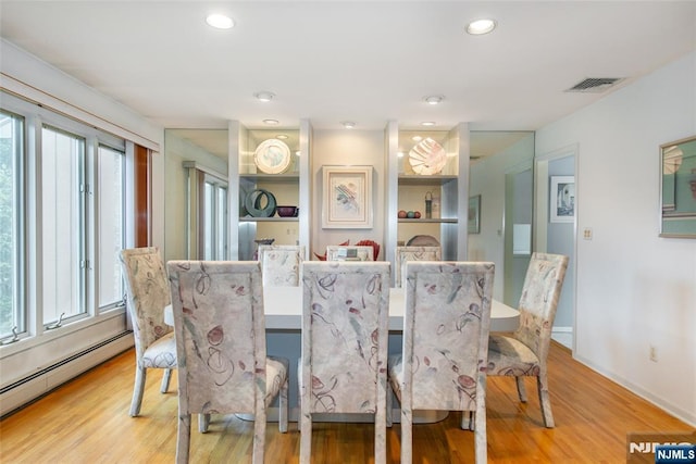 dining area featuring a baseboard heating unit, plenty of natural light, light wood-style flooring, recessed lighting, and baseboards