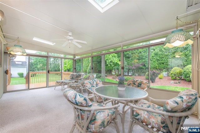 sunroom featuring a ceiling fan, outdoor dining area, and plenty of natural light
