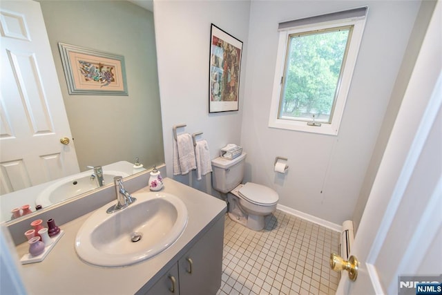 bathroom with vanity, toilet, tile patterned flooring, and baseboards