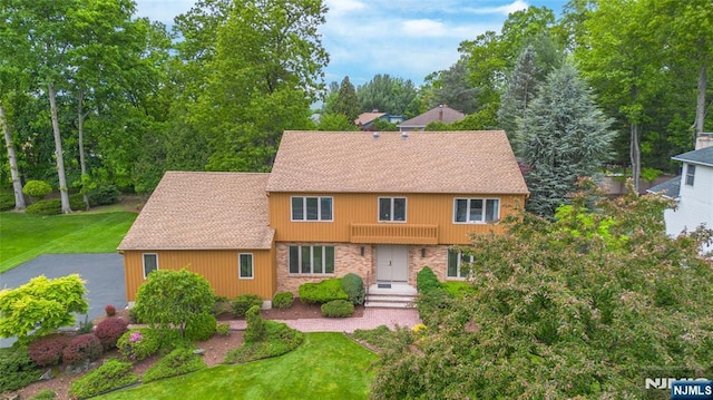 view of front of house featuring a front yard and roof with shingles