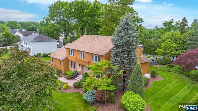 view of subject property featuring a tree filled landscape