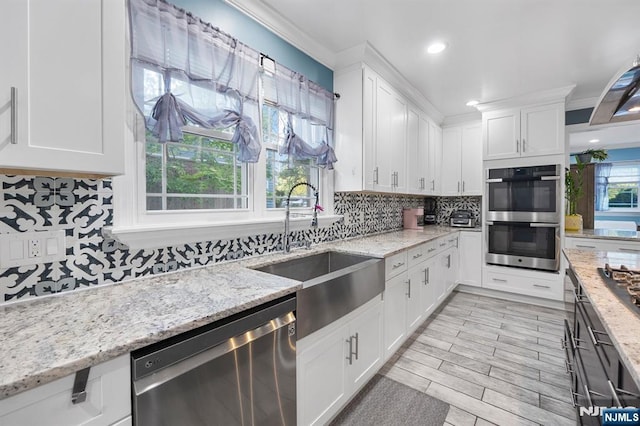 202 Elmwynd Dr, Orange, NJ 07050 - kitchen featuring appliances with stainless steel finishes, a sink, crown molding, decorative backsplash, and white cabinets