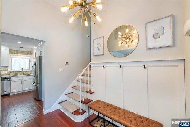stairs with a chandelier and wood finished floors