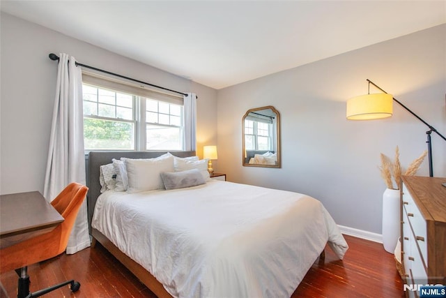 bedroom with wood finished floors and baseboards