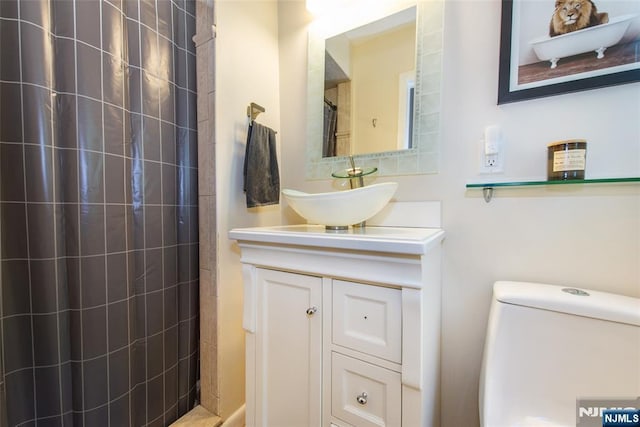 bathroom featuring a shower with shower curtain, vanity, and toilet