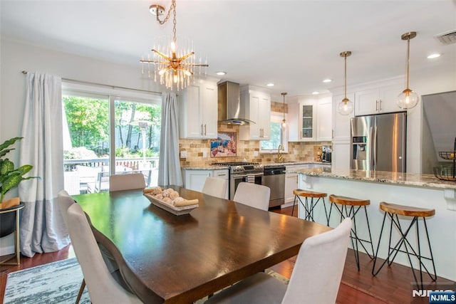 dining space featuring healthy amount of natural light, a chandelier, dark wood-style flooring, and recessed lighting