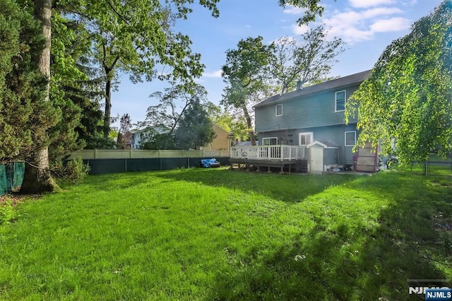 view of yard with a wooden deck and a storage shed