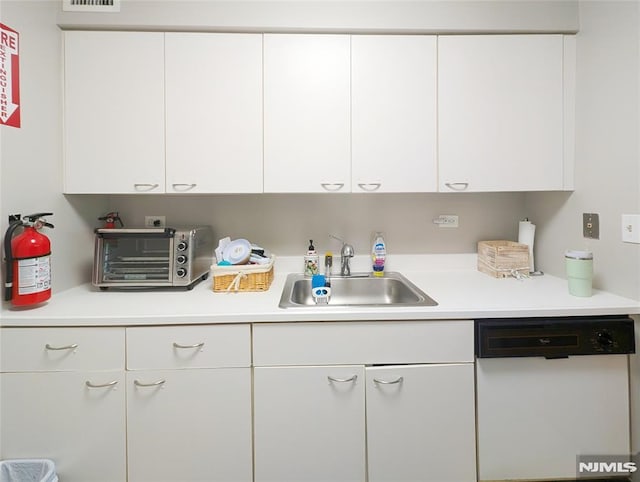 300 Main St Unit 216, Little Falls, NJ 07424 - kitchen featuring white dishwasher, a sink, white cabinetry, and light countertops