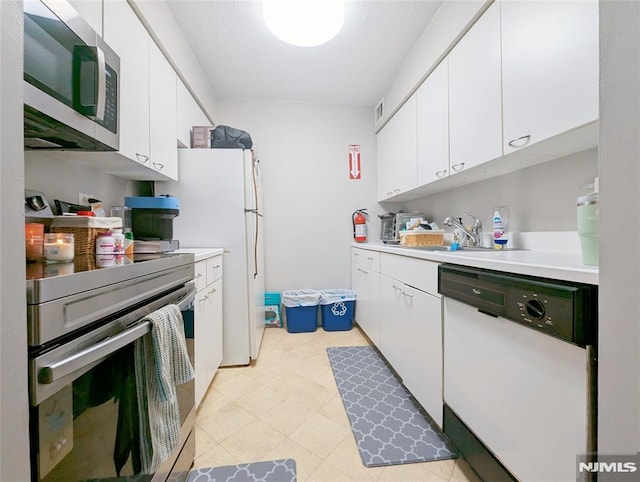 300 Main St Unit 216, Little Falls, NJ 07424 - kitchen with stainless steel appliances, a sink, light countertops, and white cabinets