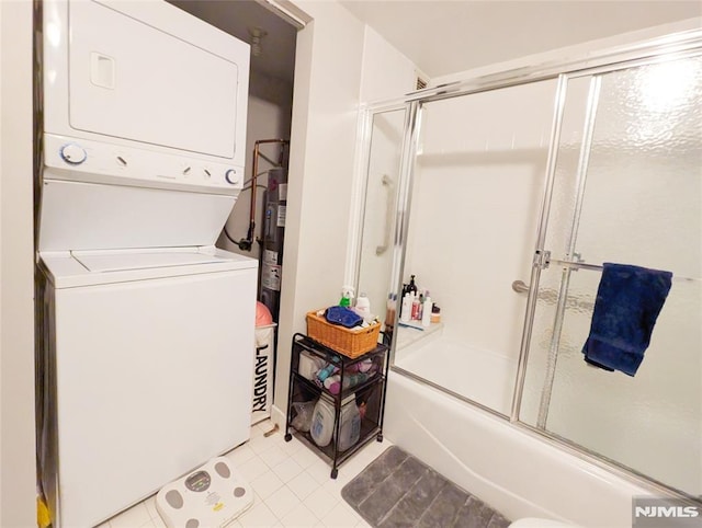 300 Main St Unit 216, Little Falls, NJ 07424 - full bath featuring estacked washer and dryer, enclosed tub / shower combo, and tile patterned flooring